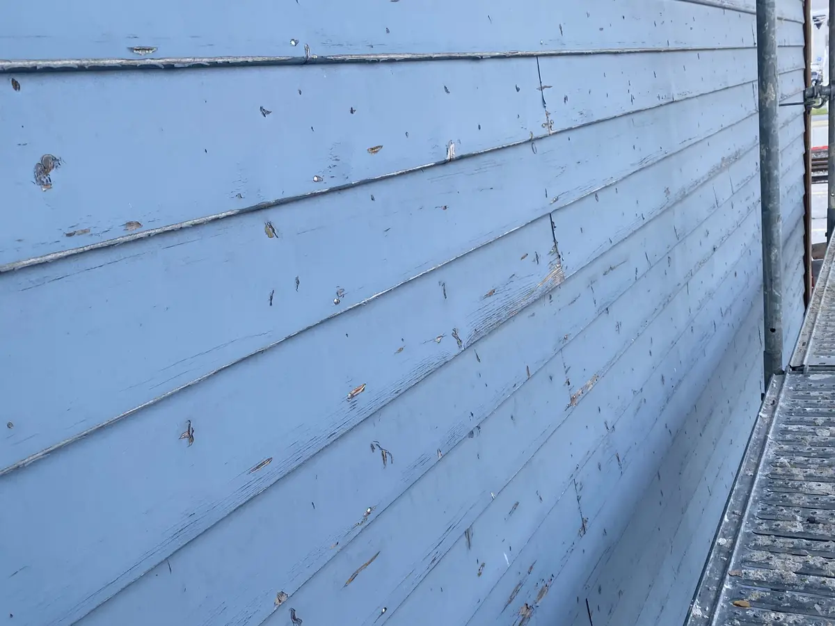 Aérogommage de la façade en bois peinte du bâtiment LANDI à Orbe - Avant intervention