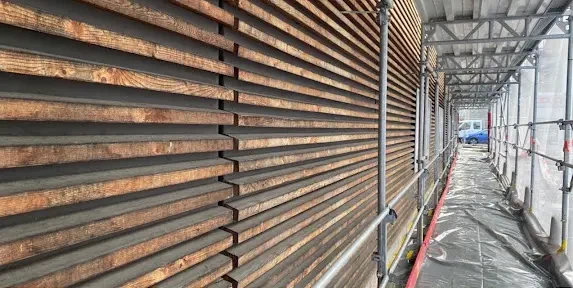Sablage et Gommage des façades en bois dans le Canton de Vaud de la Coop à Moudon : état avant les travaux